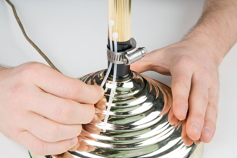 Thread two zip ties through the gap in the hose clamp